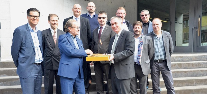 Christoph Grenacher, in Begleitung von neun Gewerbevertretern, überreichte Alex Hürzeler die Unterschriften und ein Geschenk der Solarteure am BZF.